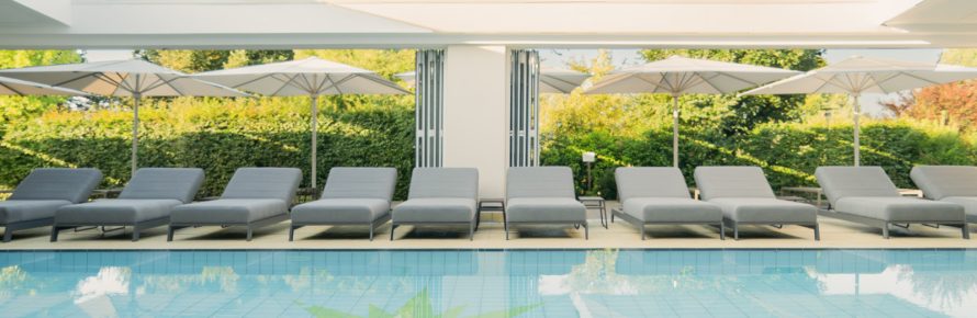 Pool mit Liegen unter blauem Himmel