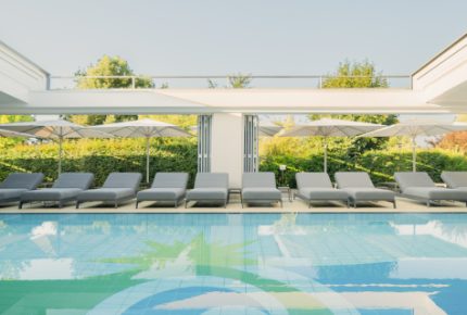Sicht vom Wasser des Pools auf die Liegen und den Himmel